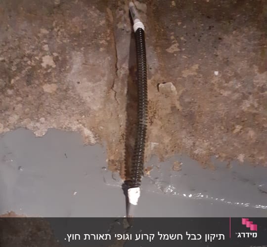 כבל חשמל שחור עם חיבור לבן על רצפה אפורה